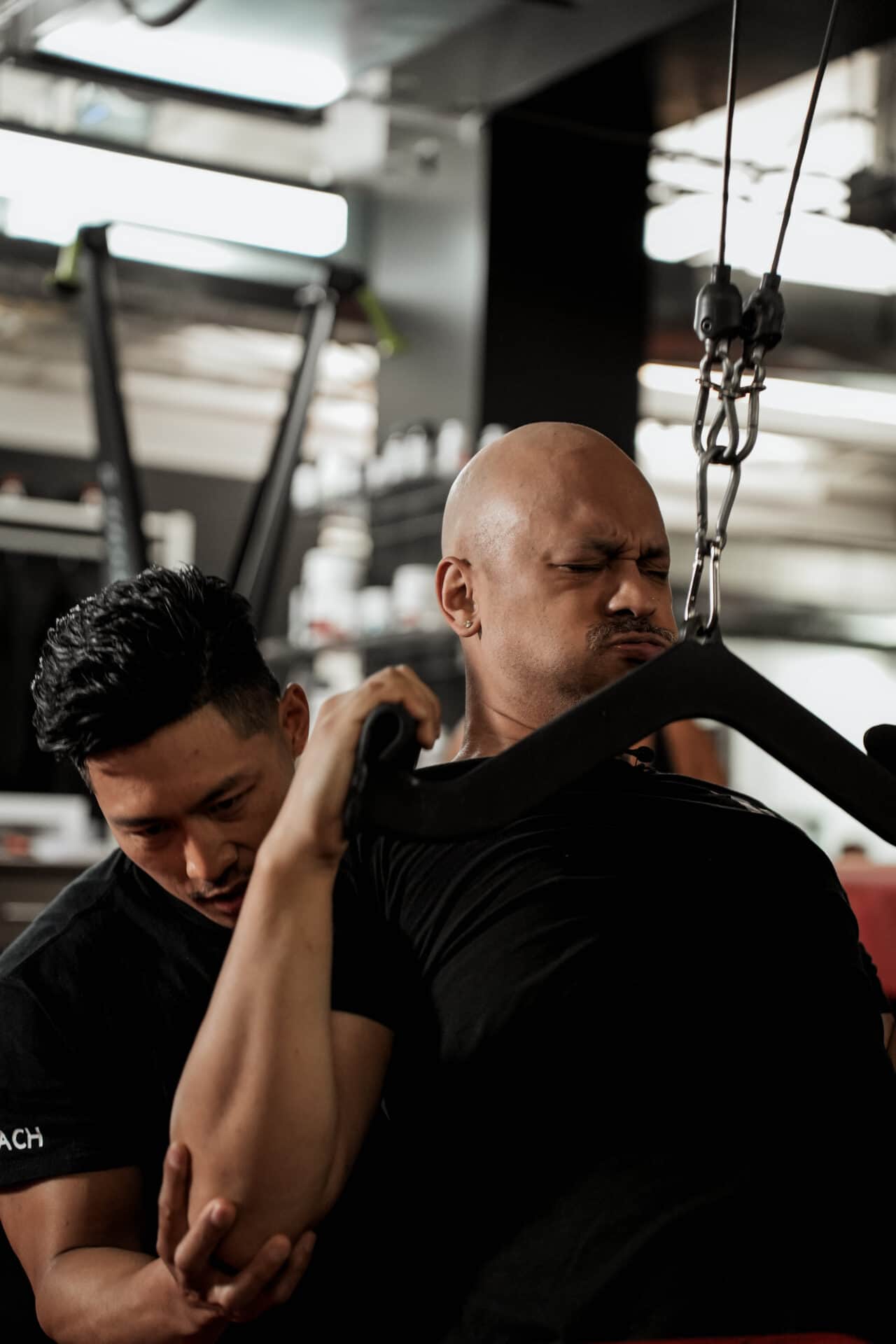 Jay coaches client through intense cable exercise — strength and performance training at Arzadon Fitness