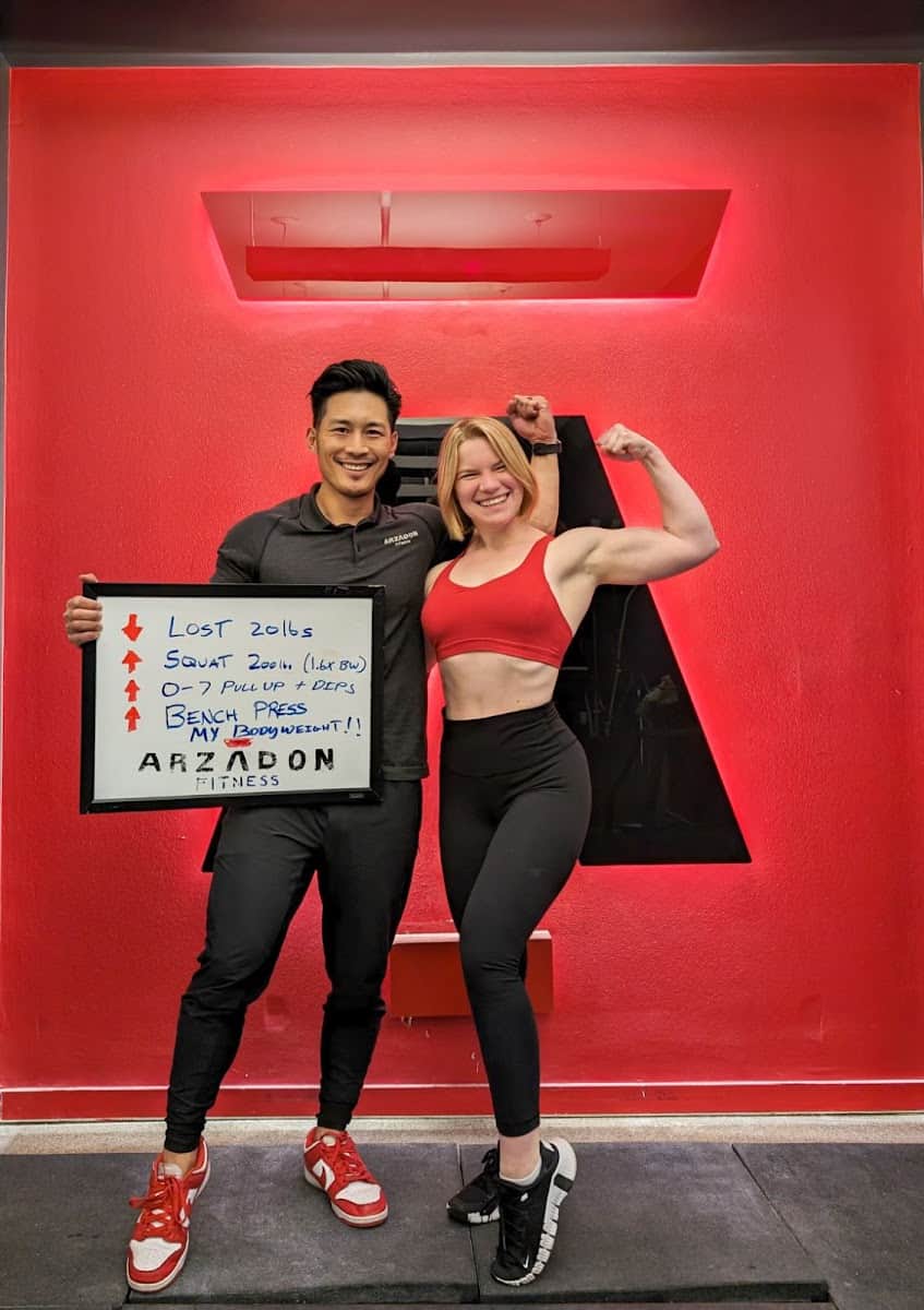 Trainer and client Emily celebrating whiteboard transformation achievements at Arzadon