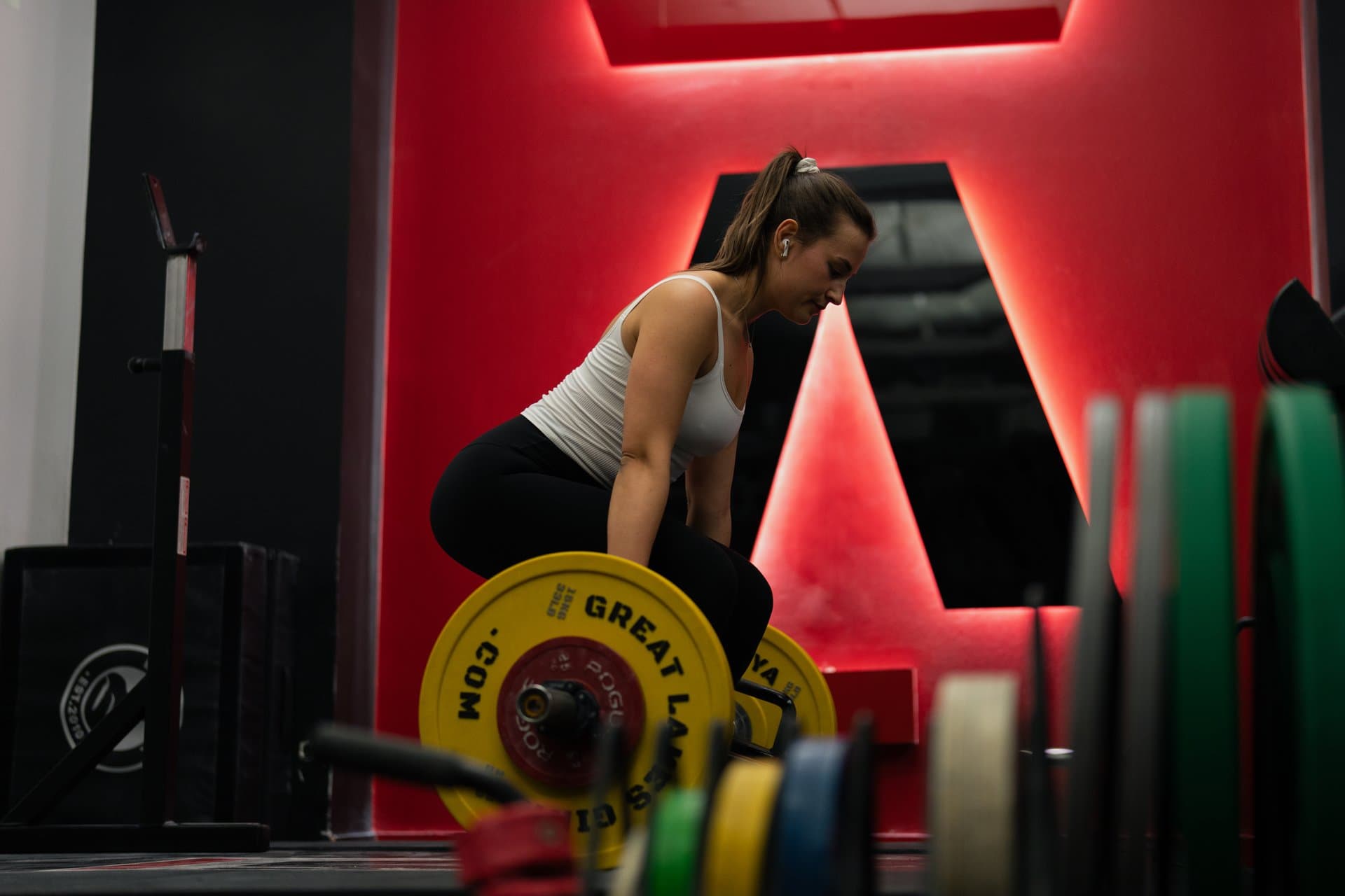 Female client pulling a barbell deadlift under the Arzadon A at Arzadon Fitness Toronto