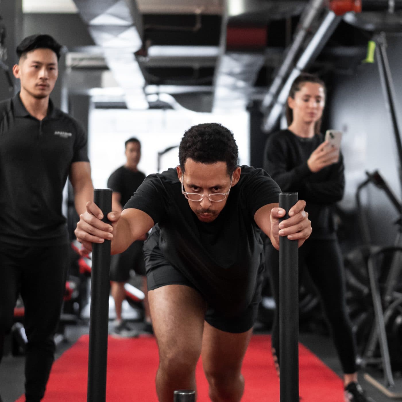 Personal trainer coaching a male client through a sled push conditioning drill at Arzadon Fitness Toronto