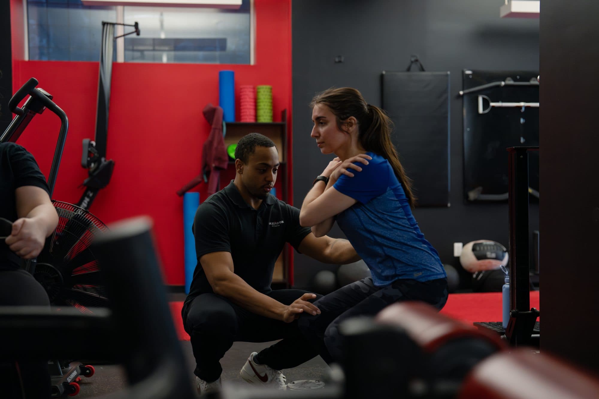 Personal trainer coaching a client's squat form at Arzadon Fitness Toronto