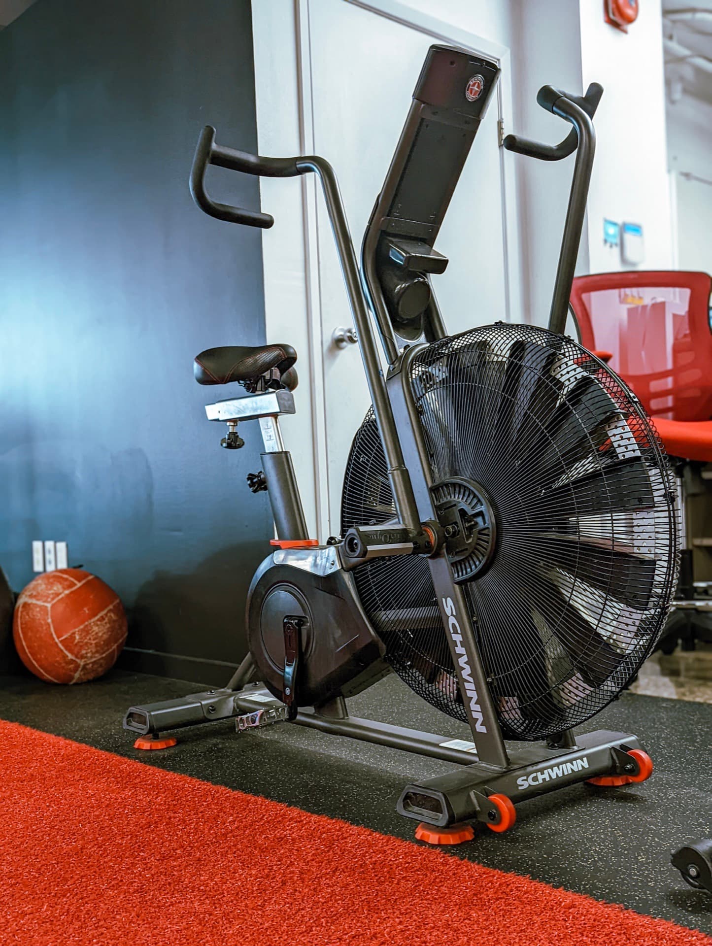 Schwinn air bike at Arzadon Fitness Toronto with large fan wheel, dual-action handlebars, and a medicine ball on the floor