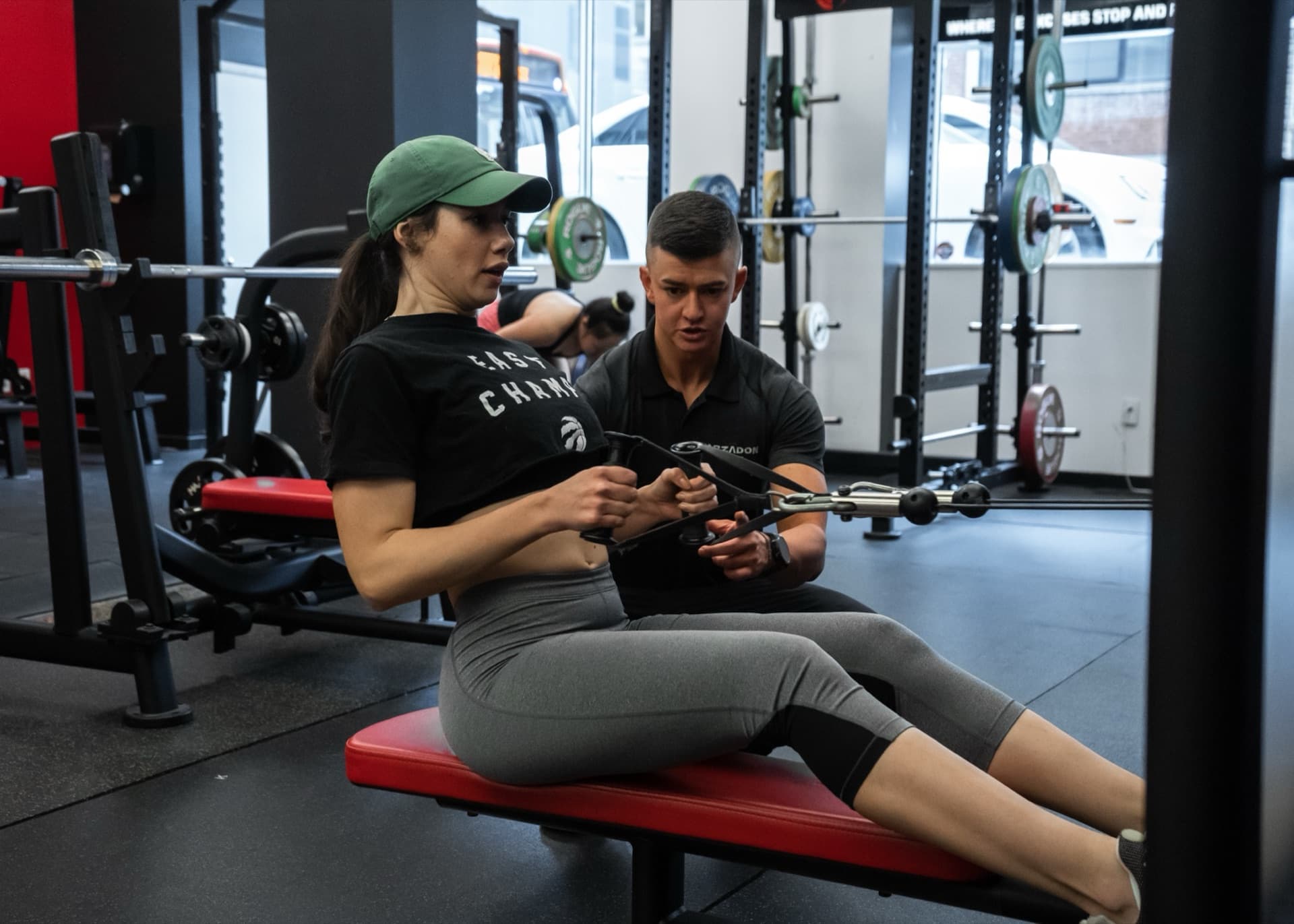 Trainer coaching female client on cable row machine in power rack at Arzadon Fitness Toronto