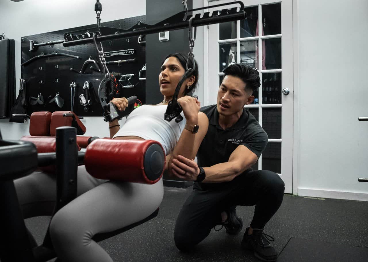 Jay Arzadon coaching a client through a lat pulldown at Arzadon Fitness, King West Toronto